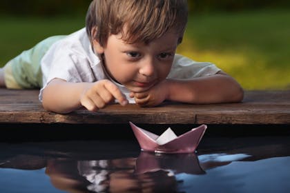 Child floating paper boat