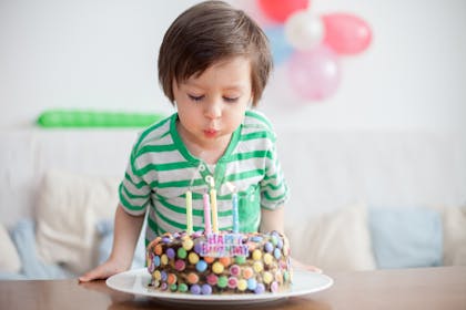 Child blowing out 4-year-old birthday candles