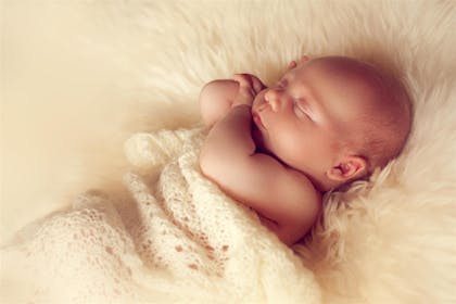 Small baby sleeping on shag rug