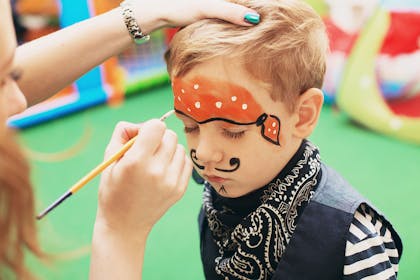 Child having face painted like a pirate