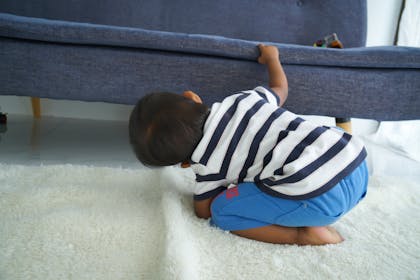 child looking under the sofa