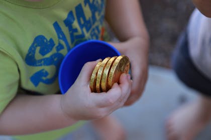 Kid holding gold foil chocolate coins