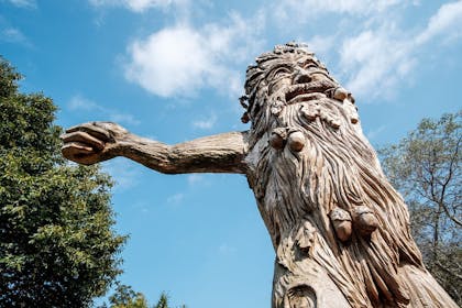 Carved wooden statue of a tree man with acorns in beard