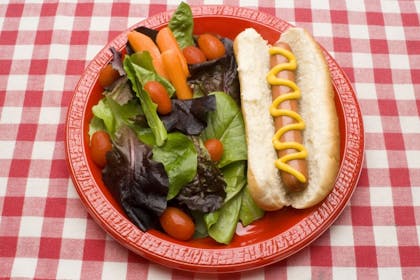 Hot dog in a bun with salad