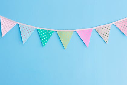 Spotty multi-coloured fabric bunting on blue background