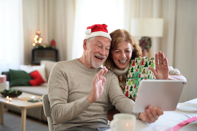 Senior couple smiling and waving at IPad on Christmas 