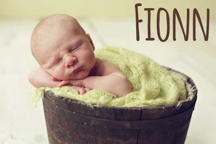Baby sleeping in basket with Irish name Fionn