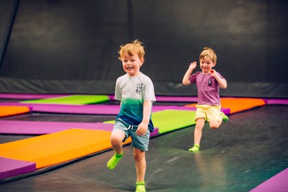 two boys running at trampoline park