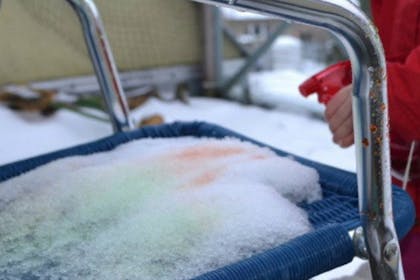 child painting snow on chair