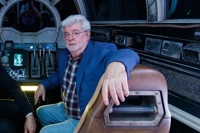 George Lucas sitting in replica Star Wars ship