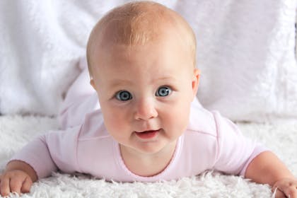 white baby with blue eyes smiling at camera