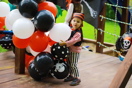 Young boy holding pirate balloons