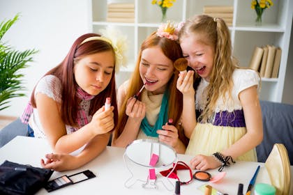 Three little girls trying out make-up