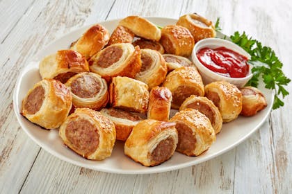 Sausage roll on a platter with ketchup