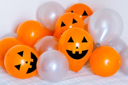 Orange halloween balloons with pumpkin faces drawn on