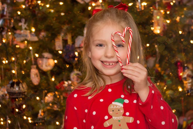 Young girl holding up candy canes