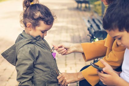 Mum zipping up a small girls coat