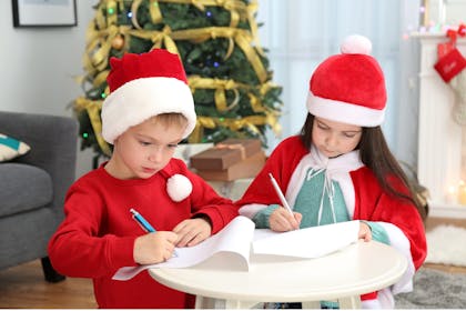 Children in santa hats writing