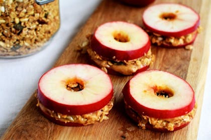 Slices of apple filled with peanut butter and granola
