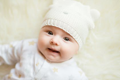 Baby wearing cream hat