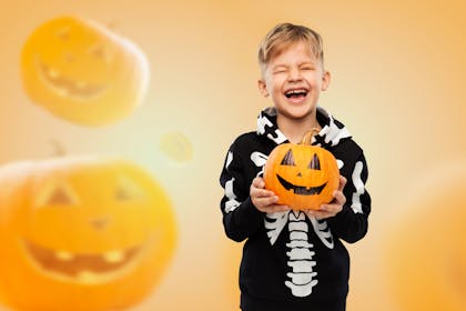 Child holding a pumpkin