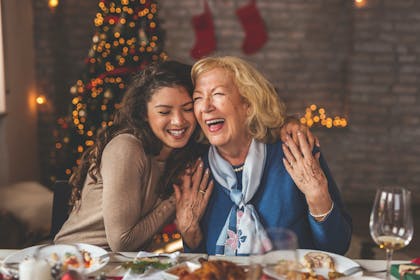 Mother and daughter laughing at the Christmas dinner table
