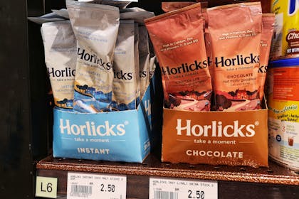 Horlicks Instant and Chocolate packets displayed for sale on a supermarket shelf