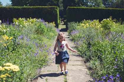 Girl running through gardens