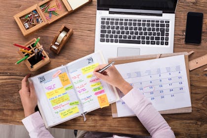 Woman planning with calendar, diary and laptop