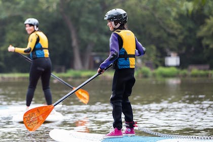 A child enjoy a paddleboard session at a Haven holiday park