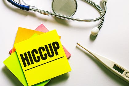 Post-it note saying 'hiccup' plus digital thermometer and stethoscope
