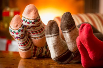 three pairs of feet wearing christmas socks