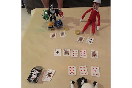 Elf on the shelf playing poker with cards
