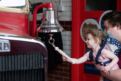 Girl ringing fire engine bell