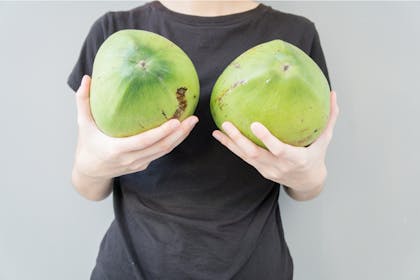 Woman holding melons as breasts