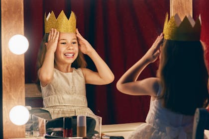 Little girl wearing crown in mirror
