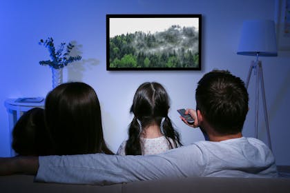 Family sitting on sofa watching a nature documentary