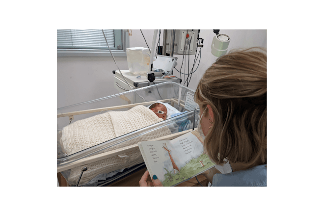 Premature baby being read to in hospital