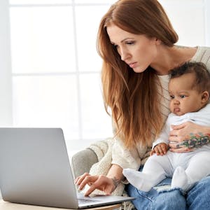 Mum using laptop with baby on her lap