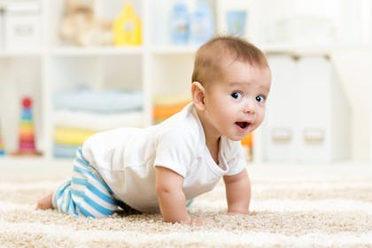 Baby crawling on all fours with eyes and mouth open