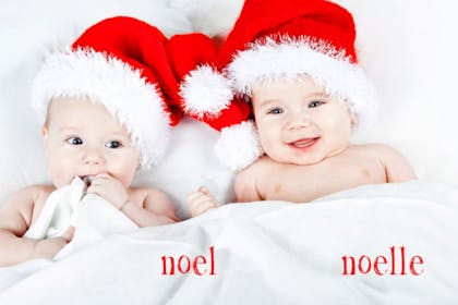 Two babies wearing Santa hats