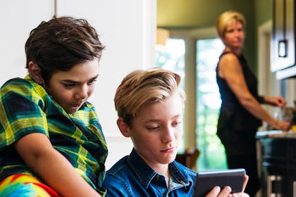 mum looking at boys on smartphone concerned about online internet safety