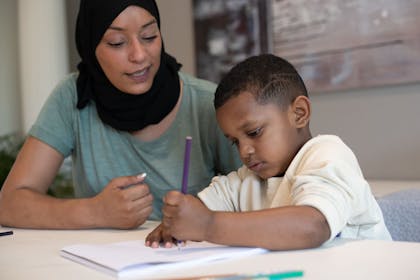 Mum helping child write