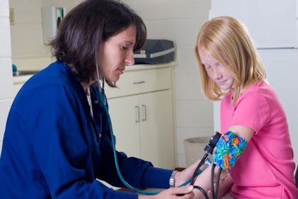 nurse taking little girl's blood pressure - School nurse