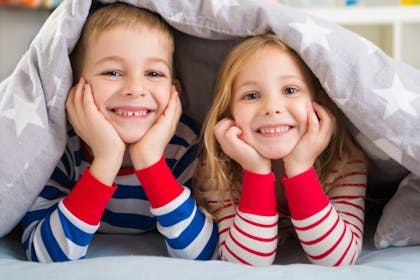 Kids in pyjamas under duvet