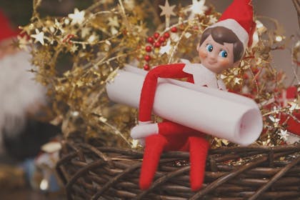 Elf on the Shelf carrying a scroll