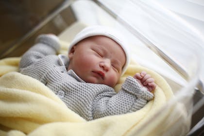 Newborn baby in hospital cot 