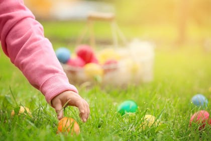 Girl picking Easter eggs in grass