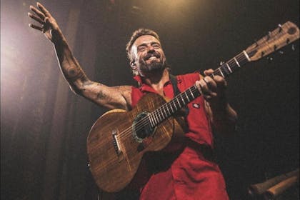 Singer Xavier Rudd on stage with a guitar 