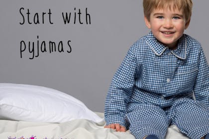 boy in pyjamas sitting on bed
